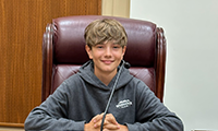  A student smiles while sitting at a desk in the Florida Capitol.
